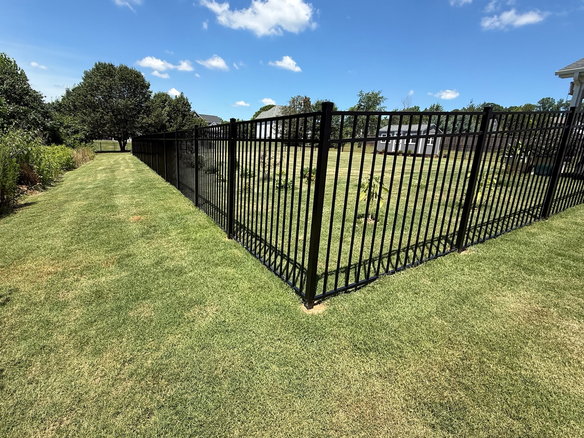 A sleek 54" aluminum fence provides both security and elegance to this well-maintained lawn, backed by a limited lifetime manufacturer's warranty for peace of mind.